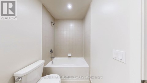 A white bathroom with a tub, toilet and sink.