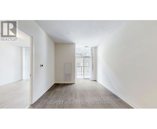 A spacious room with a door leading to another room.