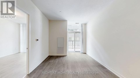 A spacious room with a door leading to another room.