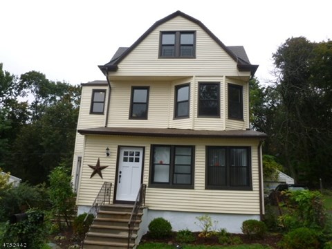 A two story house with a white door and a star above it.