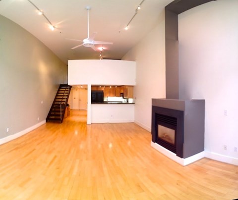 A living room with a fireplace and a staircase.