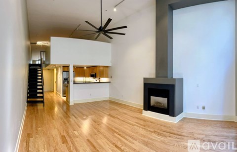 A living room with a wood floor and a fireplace.