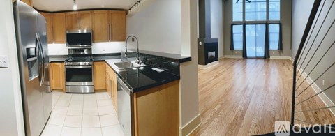 A kitchen with wooden cabinets and black countertops.