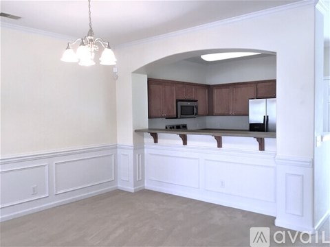 A kitchen with white cabinets and a microwave.