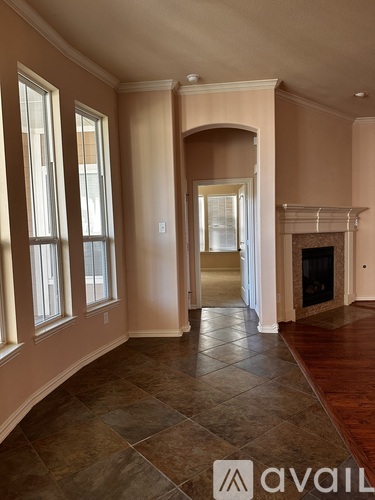 A spacious room with a fireplace and a tiled floor.