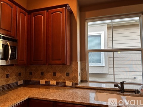 A kitchen with brown cabinets and a tiled backsplash.