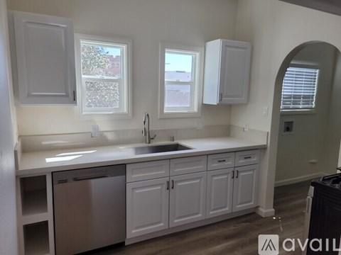 A kitchen with white cabinets and a stainless steel dishwasher.