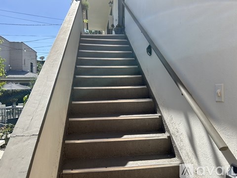 A set of stairs leading up to a building with a metal railing on the side.