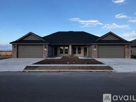 A house with a grey roof and a garage door is available for sale.