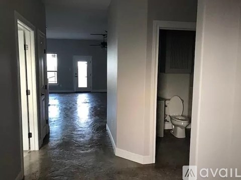 A bathroom with a toilet and a fan.