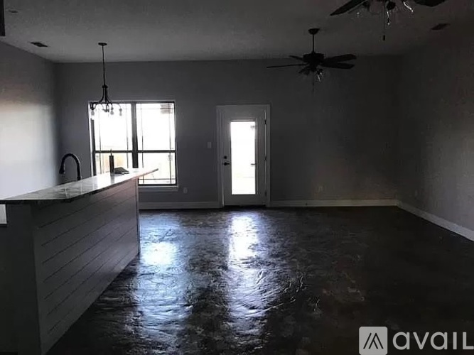 A room with a ceiling fan and a door leading to another room.