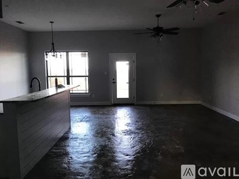 A room with a ceiling fan and a door leading to another room.