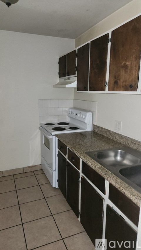 A kitchen with a white stove and a sink.