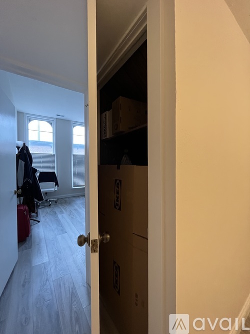 A hallway with a door on the right and a window on the left.