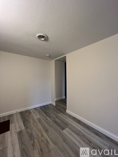 A room with a wooden floor and a white ceiling with a light fixture.