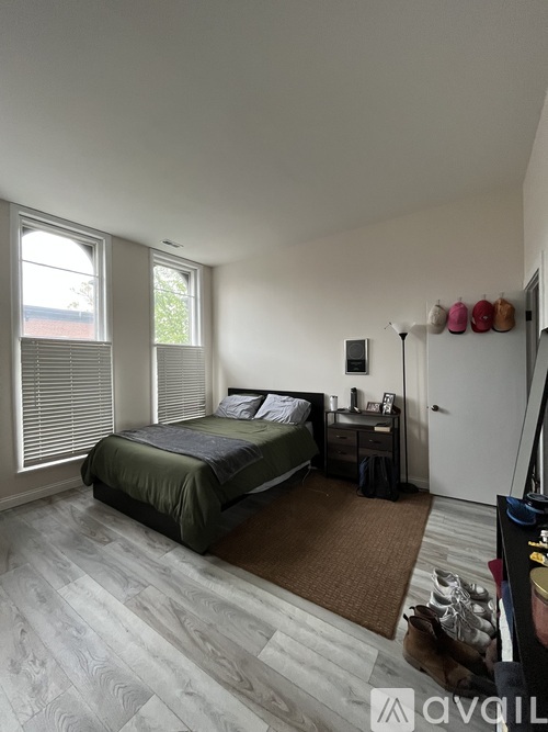 A bedroom with a bed, nightstand, and window.