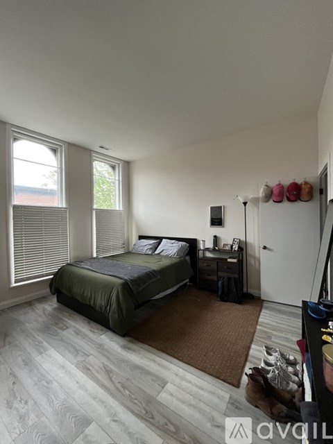 A bedroom with a bed, nightstand, and window.