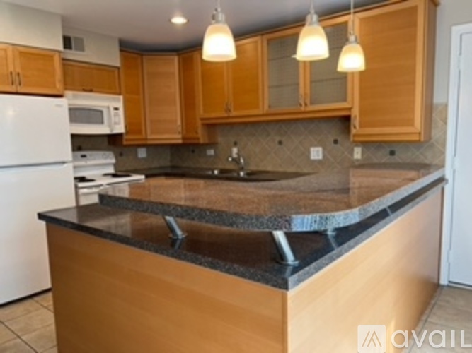 A kitchen with wooden cabinets and a granite countertop.