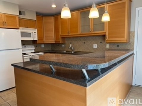 A kitchen with wooden cabinets and a granite countertop.