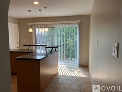 A kitchen with a counter and a window with blinds.