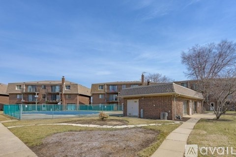 A residential area with apartment buildings and a fenced-off area in the foreground.