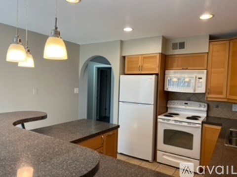A kitchen with a white refrigerator and a stove top oven.