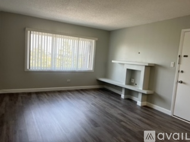 A room with a fireplace and a window with blinds.