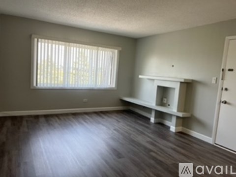 A room with a fireplace and a window with blinds.