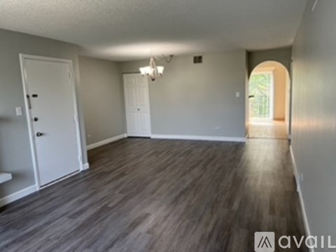 A room with wooden flooring and white walls.