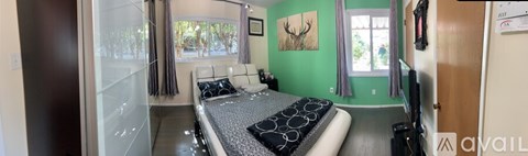 A bedroom with a bed and a painting on the wall.