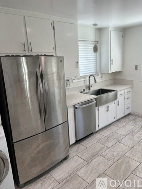 A kitchen with a stainless steel refrigerator and a sink.