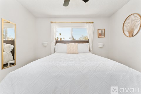 A bedroom with a large bed and a ceiling fan.