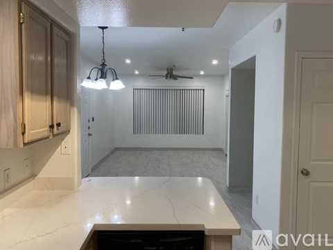A kitchen with a marble countertop and a ceiling fan.