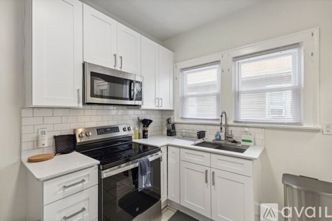 A kitchen with white cabinets and a black stove top oven.
