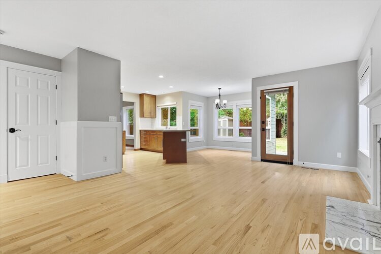 A spacious living room with wooden floors and a large window.