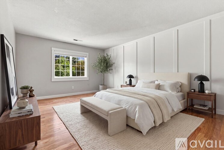 A bedroom with a large bed, a window, and a television.