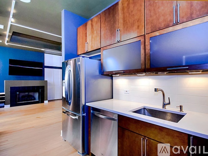 A kitchen with a stainless steel refrigerator and wooden cabinets.
