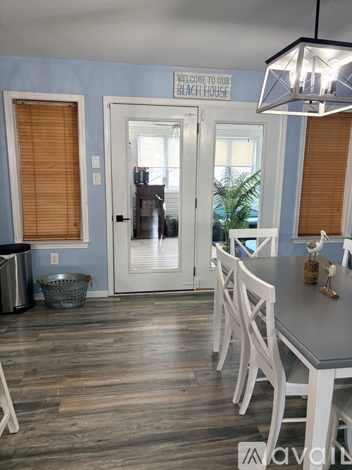 A dining room with a table and chairs and a sign that says "Welcome to our beach house".
