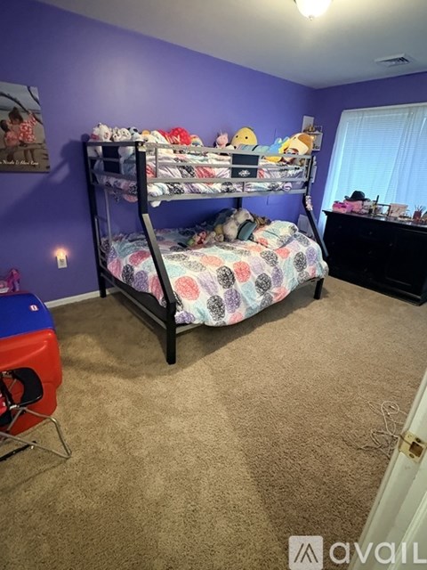 A bedroom with a bunk bed and a chair.