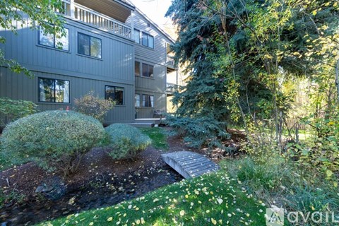 A modern house with a grey exterior and a landscaped garden.