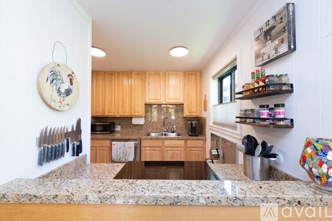 A kitchen with wooden cabinets and a marble countertop.