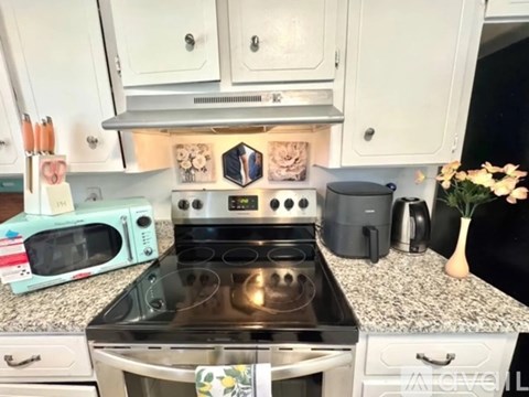 A kitchen with a stove top oven and a microwave on the counter.