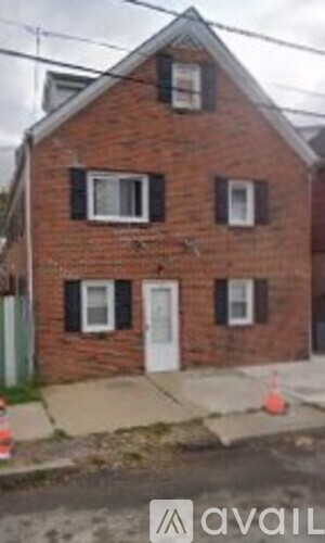 A brick house with a white door and windows.