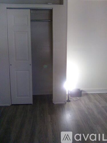 A room with a white door and a light on the floor.