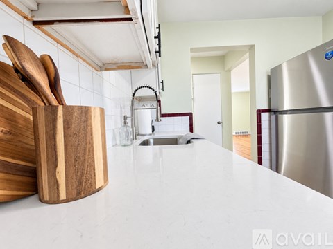 A kitchen counter with a set of wooden utensils in a holder.