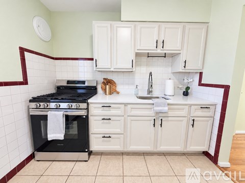 A kitchen with a black stove top oven and white cabinets.