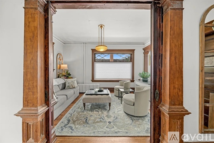 A living room with a grey sofa and a rug.