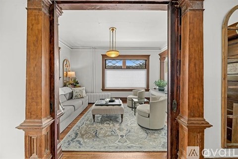 A living room with a grey sofa and a rug.