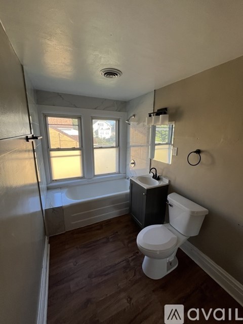A white toilet in a bathroom with a window.