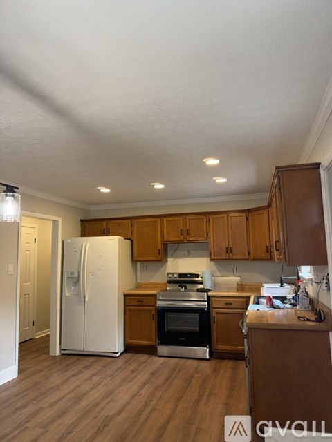 A kitchen with wooden cabinets and a white refrigerator.